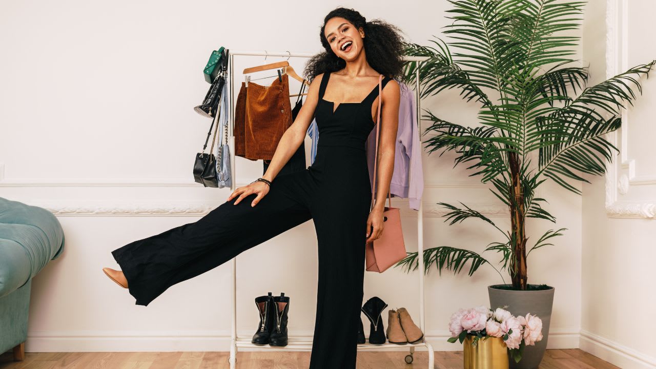 Girl in Black Jumpsuit with Clothes Rack Behind
